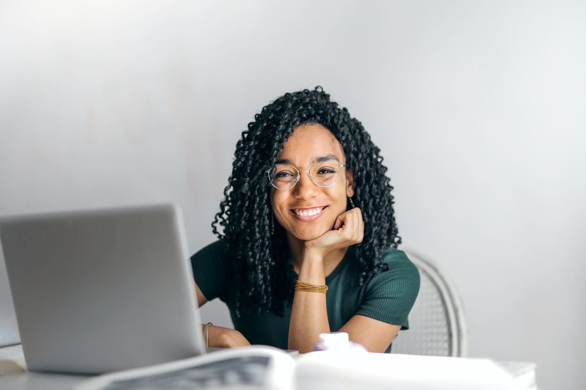 A smiling student working at a laptop